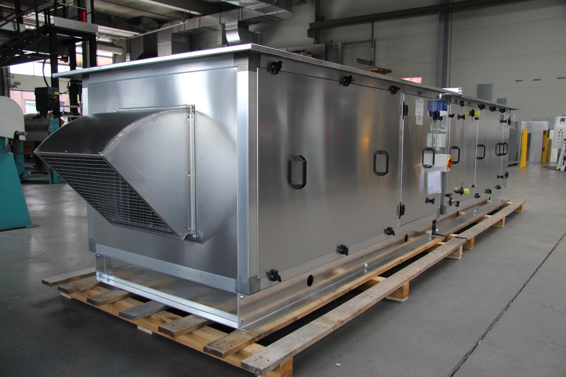 Großes Lüftungsgerät aus Metall auf Palette in Industriewerkstatt aufgestellt.